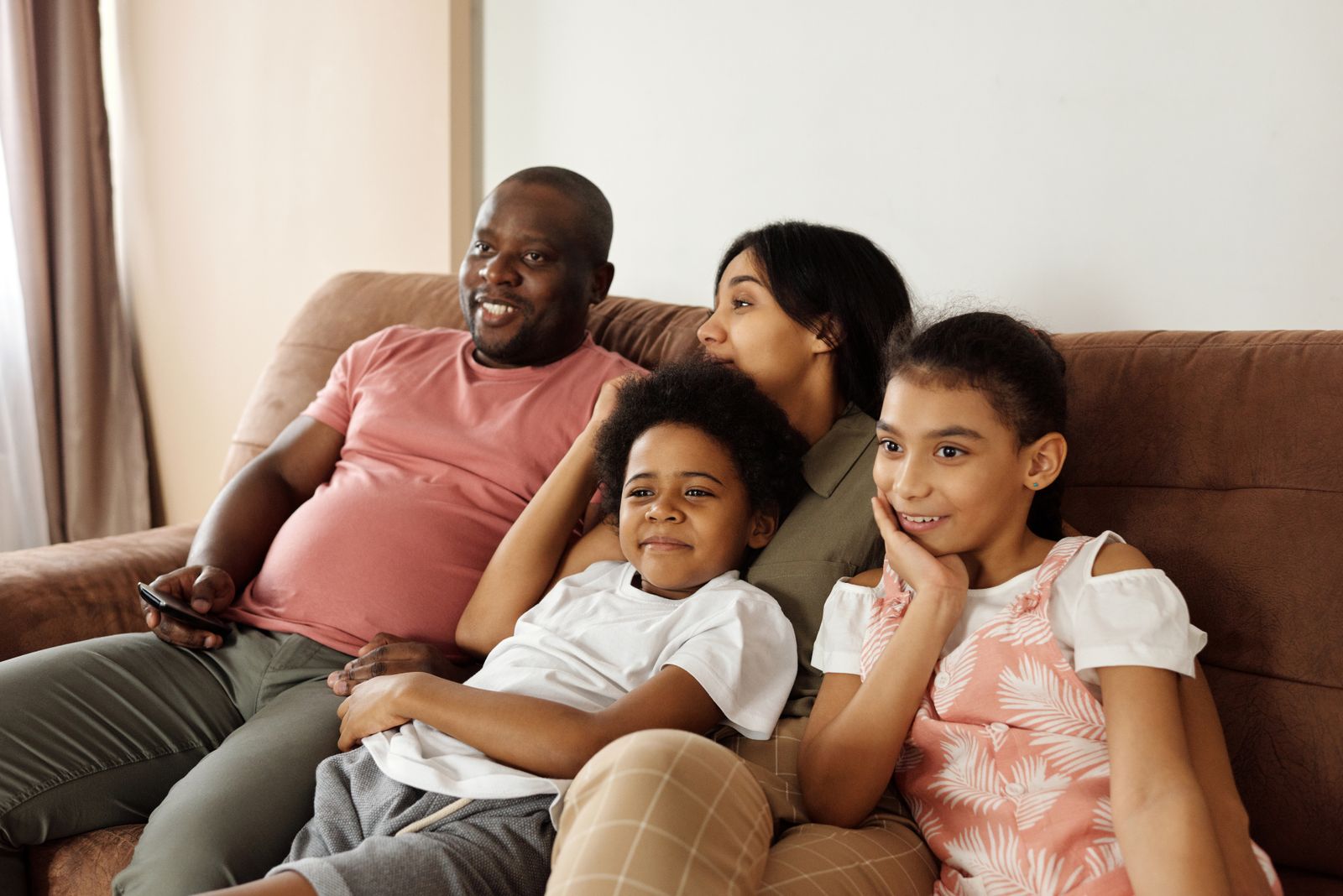 Family sitting together on a sofa watching television